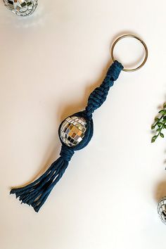 a keychain with a disco ball and tassel hanging from it's side