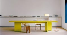 a yellow table and chairs in a room