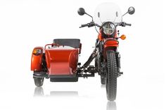 an orange motorcycle with a side car attached to the front wheel and passenger seat, on a white background