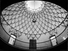 the inside of a building with a circular window and iron railings on it's sides