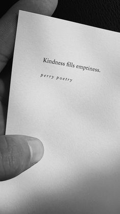 a person holding up a piece of paper with the words kindness fills emptness