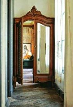 an open doorway leading to a bedroom with a mirror on the wall