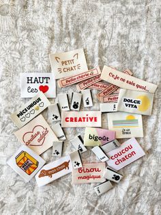 several different types of stickers on a bed sheet with words and phrases written all over them