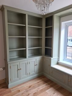 an empty room with built in bookshelves and a chandelier