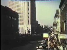 a city street with tall buildings and cars driving down it's road in the distance