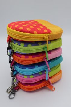 a stack of multicolored polka dot zipper pouches