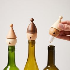 three wine bottles are lined up in a row and one is holding a small bottle