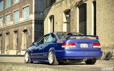 a blue car parked in front of a brick building