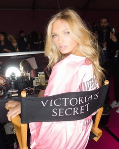 a woman sitting in a chair with a victoria's secret sign on it