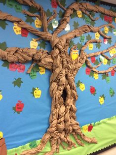 a bulletin board with a tree made out of rope and paper machs on it