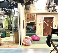 a man sitting on top of a pink bean bag in front of a tv set