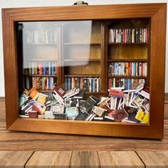 a wooden book case filled with lots of books on top of a hard wood floor