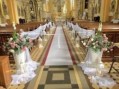 an aisle decorated with flowers and candles for a wedding ceremony in a church or chapel