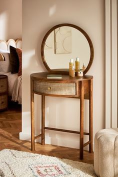 a mirror sitting on top of a wooden table next to a white rug in a room