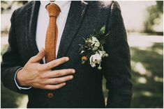 a man wearing a suit and tie with flowers in his lapel flower pin on his chest