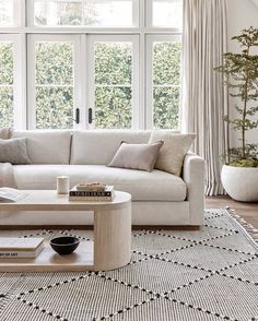 a living room with white couches and large windows in it's center area