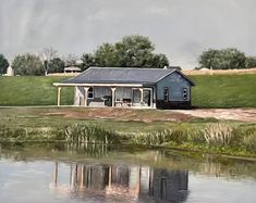 a painting of a blue house on the side of a lake with grass and trees in the background