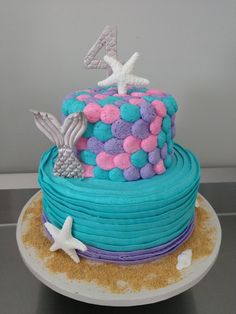 a birthday cake decorated with blue, pink and purple icing