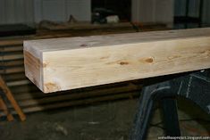 a piece of wood sitting on top of a wooden bench in a room filled with lumber