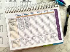 a calendar and pen sitting on top of a table next to a calculator