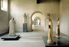 statues are lined up in the middle of a room with white walls and flooring