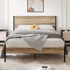 a bed with a wooden headboard and foot board in a white walled room next to a painting on the wall