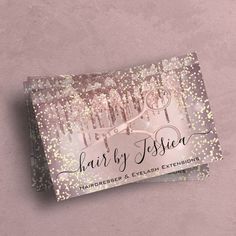 the foiled business card is displayed on a pink surface with gold and silver confetti