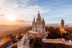 an aerial view of a cathedral in the middle of a city with mountains behind it