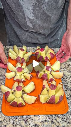 a man is cutting up apples on an orange tray