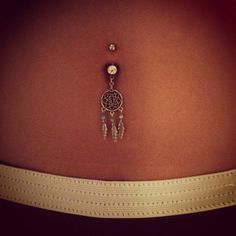 the back of a woman's stomach with a dream catcher attached to her belly