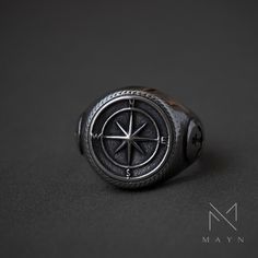 a compass ring is shown on a black surface