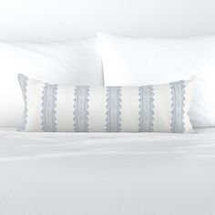 a white bed topped with pillows and blankets