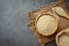 two wooden spoons are next to some grain