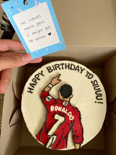 a birthday cake in a box with the name ronaldo on it and a tag that says happy birthday to ronaldo