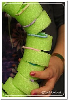 a woman is holding several rolls of neon green tape