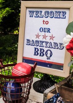 welcome to our backyard bbq sign with red, white and blue balls in a basket