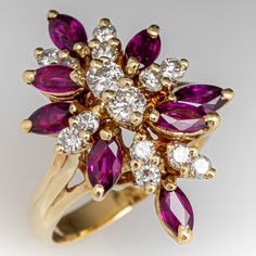 The cluster style ring is accented with fourteen (14), prong set, round brilliant cut diamonds and eight (8), prong set, marquise mixed cut natural rubies. The ring measures 21.3mm at the top, rises 10.3mm above the finger, tapering to 2.5mm wide and 1.0mm thick at the base of the shank. It is currently a size 5. Multi-stone Cluster Ruby Ring, Multi-stone Ruby Cluster Ring, Marquise Ruby And Diamond Multi-stone Ring, Ruby Multi-stone Cluster Ring, Formal Red Marquise Cut Cluster Ring, Multi-stone Ruby Cluster Diamond Ring, Marquise Ruby Cluster Ring In Fine Jewelry Style, Ruby Marquise Cluster Ring For Anniversary, Red Diamond Cluster Ring