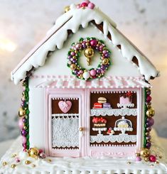 a decorated gingerbread house with a wreath on top