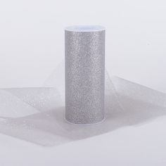 a silver vase sitting on top of a white table covered in sheer fabric and glitter