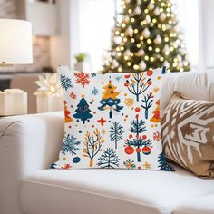 a living room with a christmas tree in the background and pillows on the couches