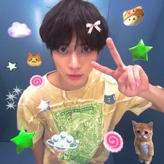 a young boy making the peace sign with his fingers while surrounded by stars and candies