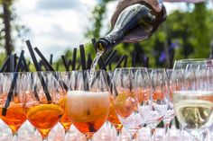 several glasses filled with different types of wine being poured into them and lined up on top of each other