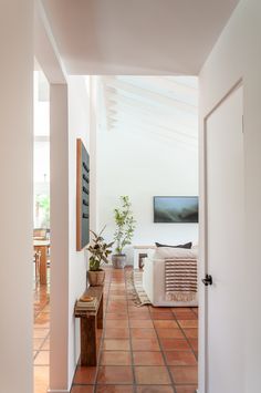 living room design, frame tv, wall art, Saltillo tile, white couch, wood bench, textiles Tile Apartment Living Rooms, Saltillo Tile Living Room Modern, Spanish Tile Bedroom, Terracotta Flooring Living Room, Terracota Tiles Floor Modern, Spanish Tile Living Room, Mexican Tile Floor Living Room, Terracotta Floors Living Room, Terracotta Tile Bedroom