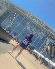 a woman is standing in front of a stadium