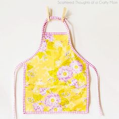 a yellow apron with pink and white flowers on it