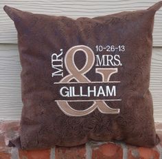 a brown and white pillow sitting on top of a brick wall