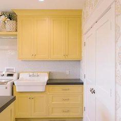 a kitchen with yellow cabinets and black counter tops