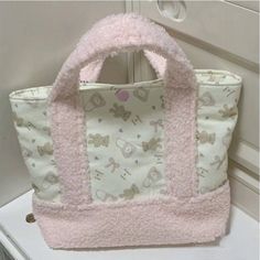 a pink and white bag sitting on top of a counter next to a door handle