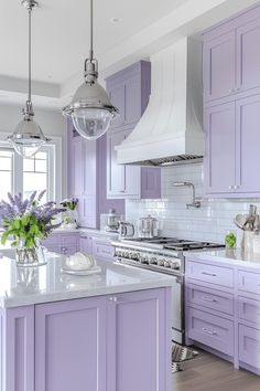 a kitchen with purple cabinets and white counter tops, along with a center island in the middle