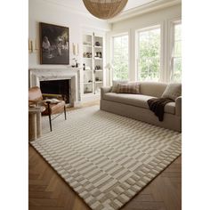 a living room filled with furniture and a fire place next to a large white rug